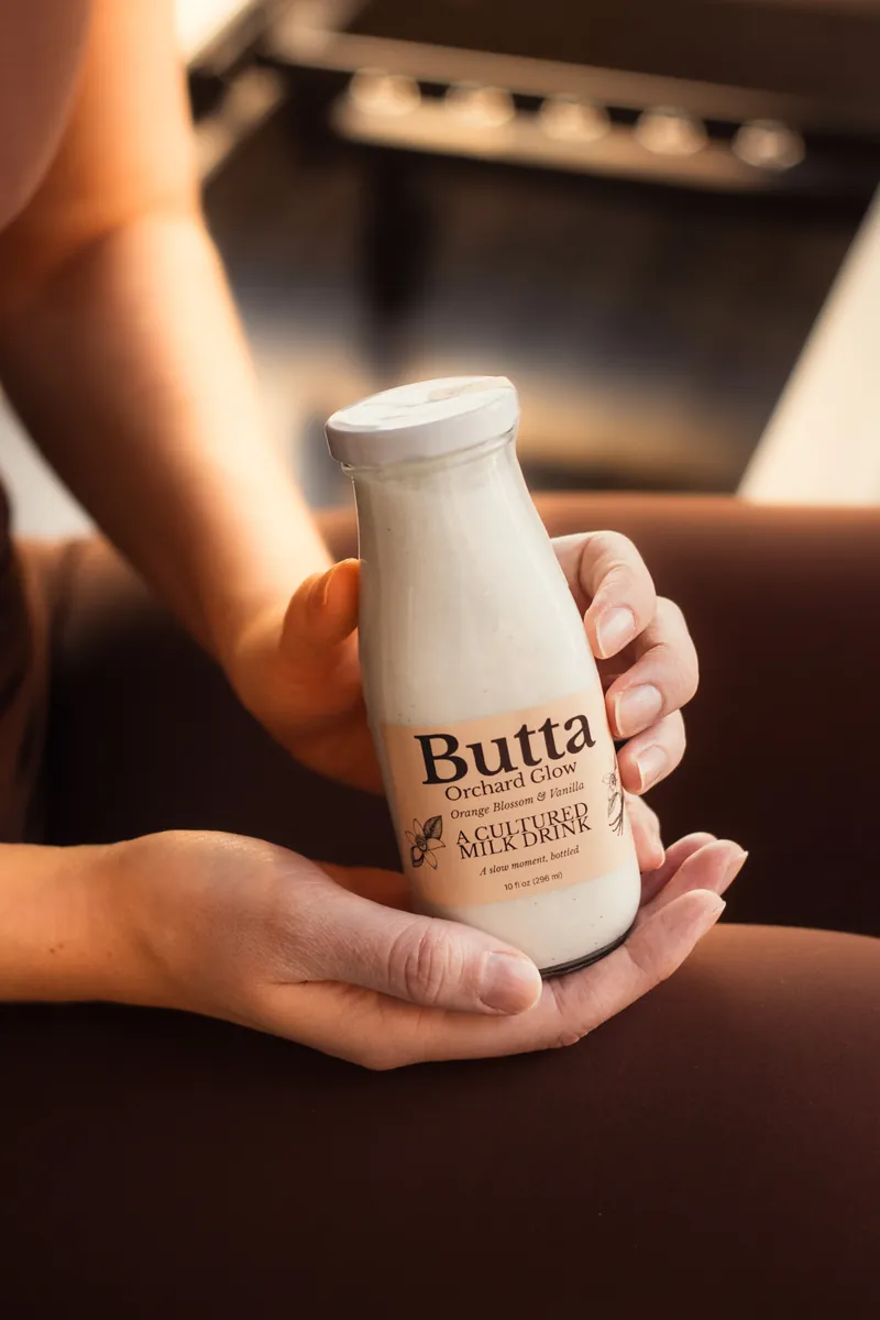 Holding a bottle of Orchard Glow after a Pilates class