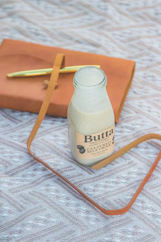 A journal and a bottle of Butta on a blanket