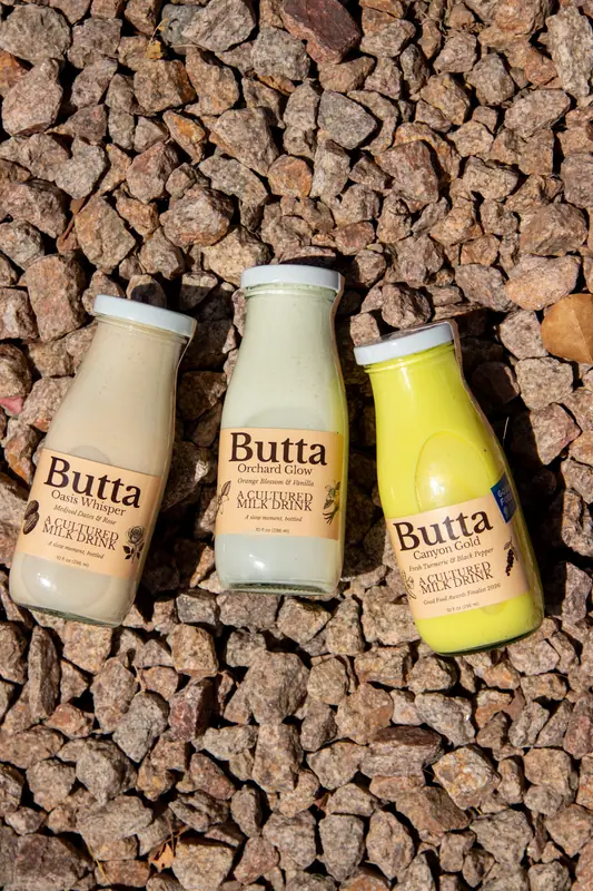 Three Butta bottles on desert gravel