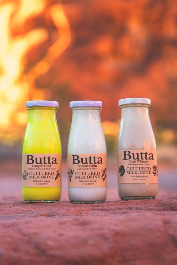 Three Butta cultured milk drinks photographed outdoors in the Arizona desert