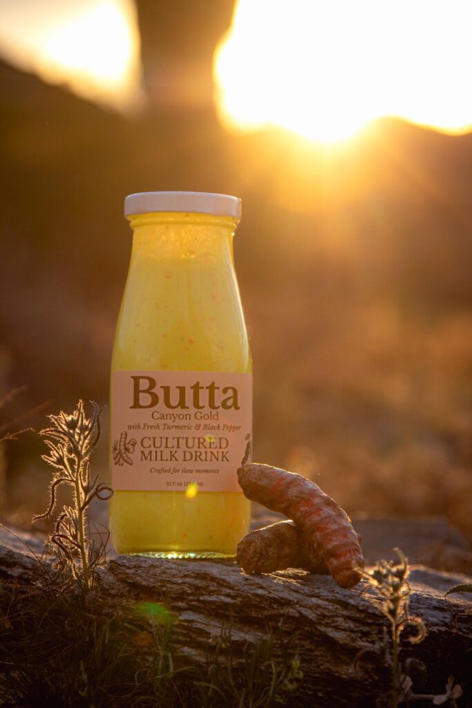 Butta Canyon Gold cultured milk drink bottle on a desert rock in warm sunset light