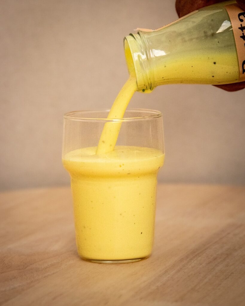 Butta Canyon Gold cultured milk drink being poured into a glass, showing smooth creamy texture