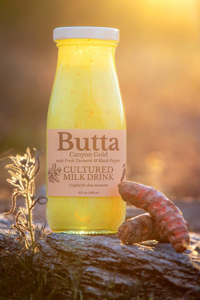 Butta Canyon Gold cultured milk drink bottle on a desert rock in warm sunset light