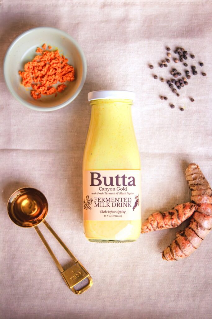Butta Canyon Gold with fresh turmeric, black pepper, and honey ingredients on a neutral linen background